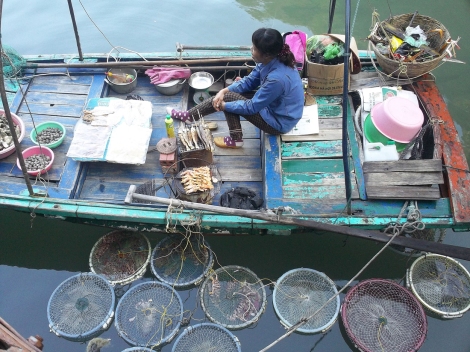 6. Une habitante vend ses poissons sous forme de brochette.