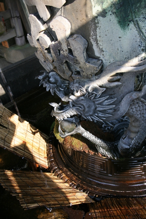 19. Sur le parvis du temple, une fontaine à effigie du Dragon.